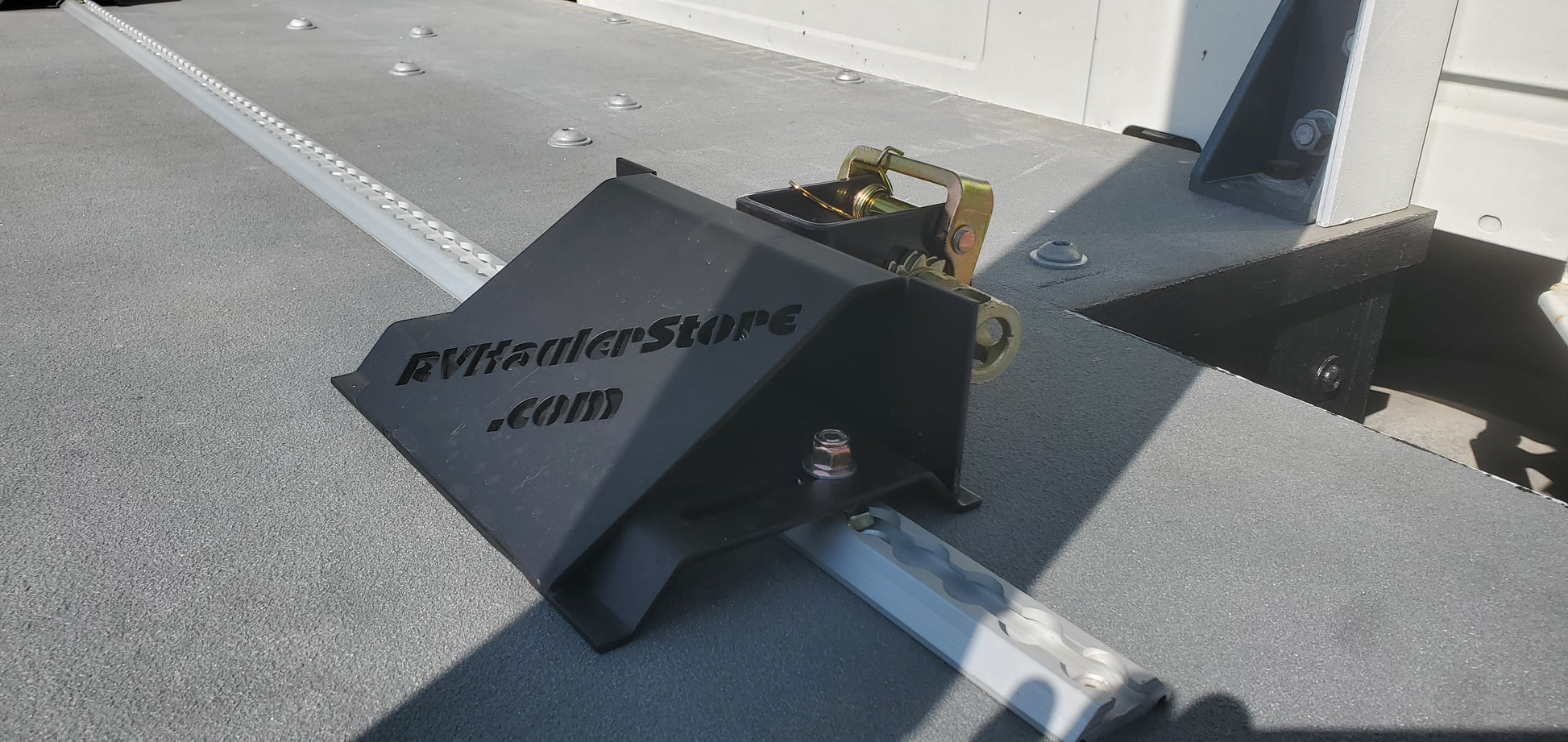 Black hitch receiver on a flatbed trailer with 'rvtrailerstore.com' branding.